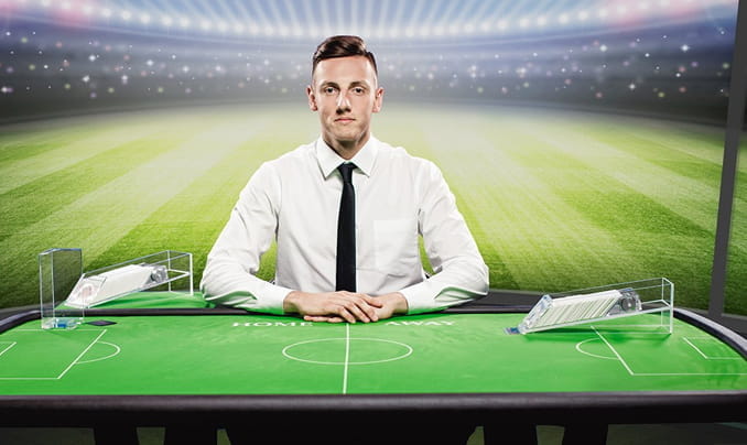 The picture shows two real dealers moderating the Live Football Studio game from Evolution Gaming.